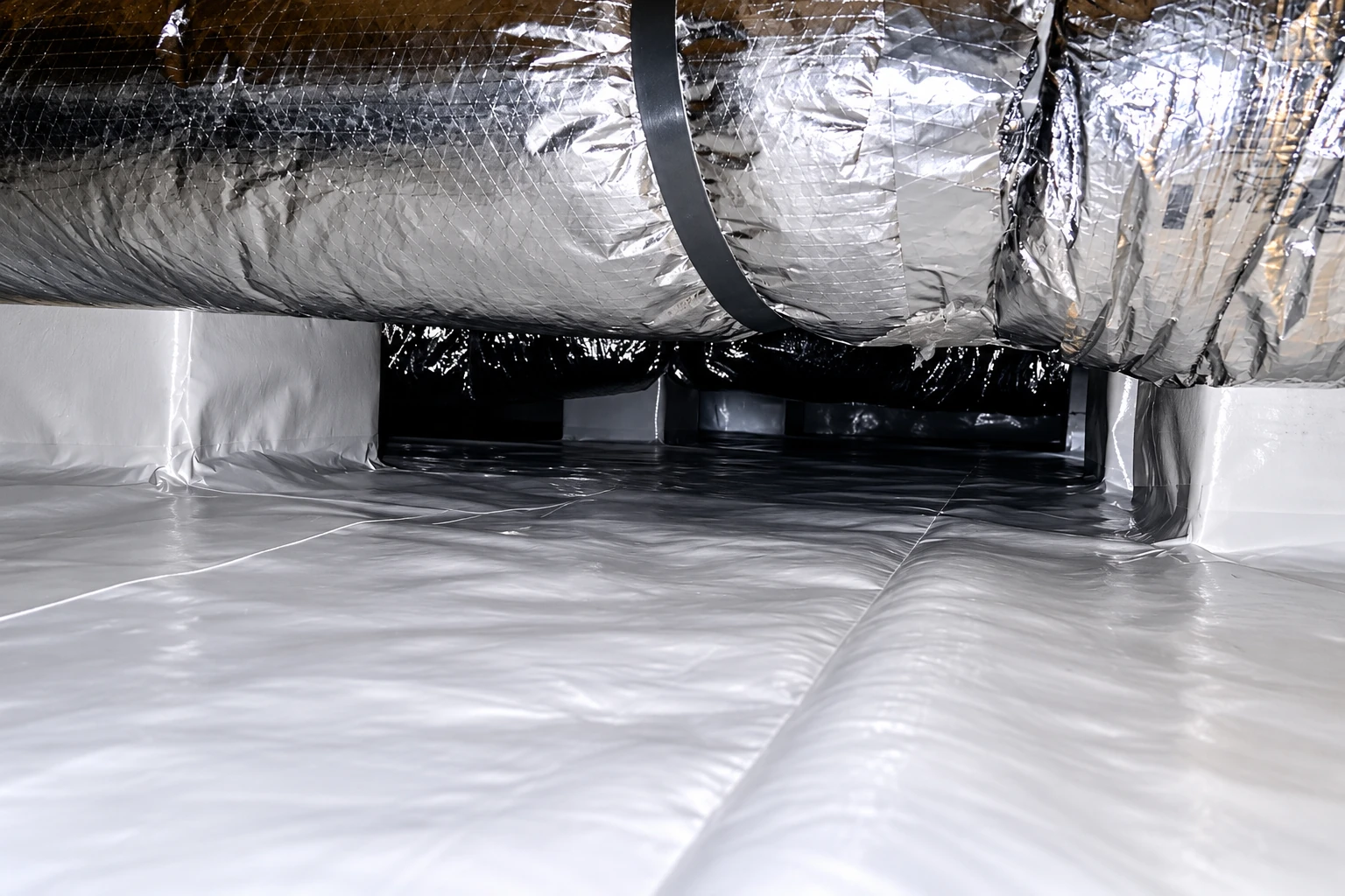 Silver insulated duct runs above a crawl space lined with smooth white plastic sheeting.